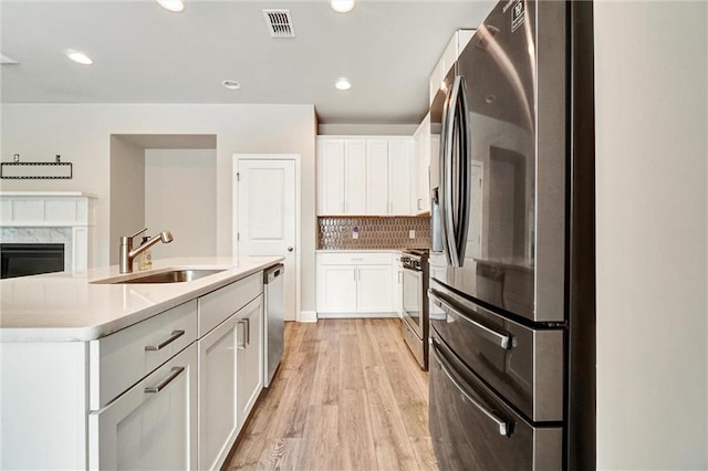 1858 Belmore St SE, Smyrna, GA 30080 - kitchen featuring stainless steel appliances, light wood-style floors, white cabinets, backsplash, and recessed lighting