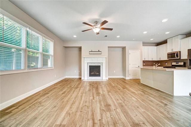 1858 Belmore St SE, Smyrna, GA 30080 - unfurnished living room with ceiling fan, light wood-style floors, recessed lighting, and a high end fireplace