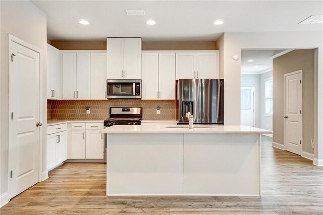 1858 Belmore St SE, Smyrna, GA 30080 - kitchen with stainless steel appliances, light countertops, a kitchen island with sink, white cabinets, and recessed lighting
