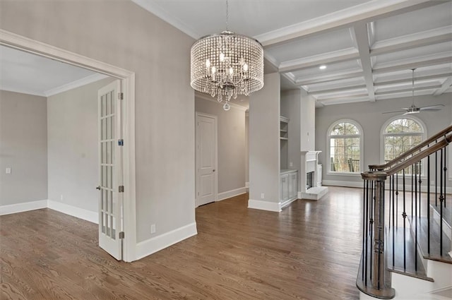 unfurnished dining area featuring stairs, coffered ceiling, wood finished floors, and beamed ceiling