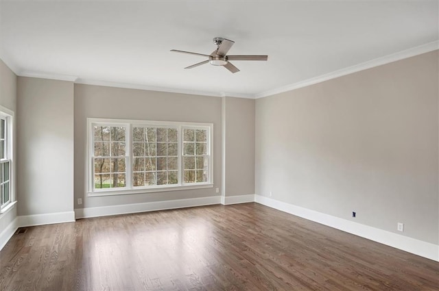 empty room featuring ornamental molding, wood finished floors, and baseboards