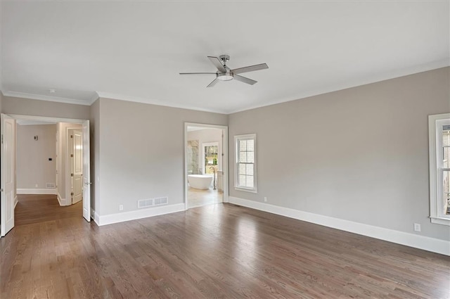 spare room with baseboards, visible vents, and wood finished floors