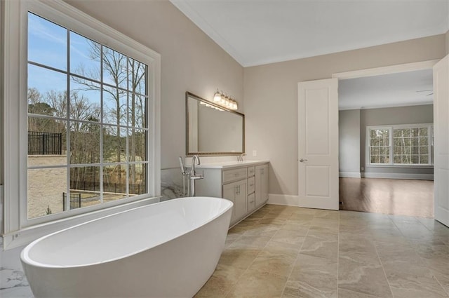 bathroom with a freestanding bath, vanity, and baseboards