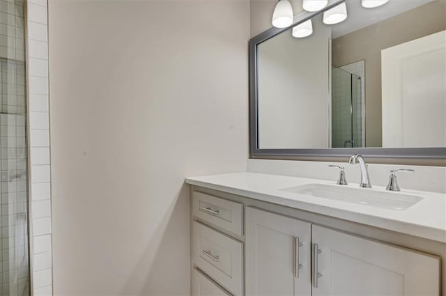 full bath featuring tiled shower and vanity