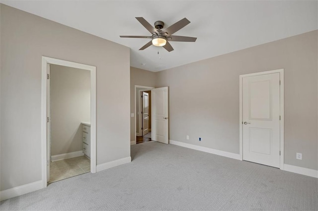 unfurnished bedroom featuring light carpet, baseboards, and connected bathroom