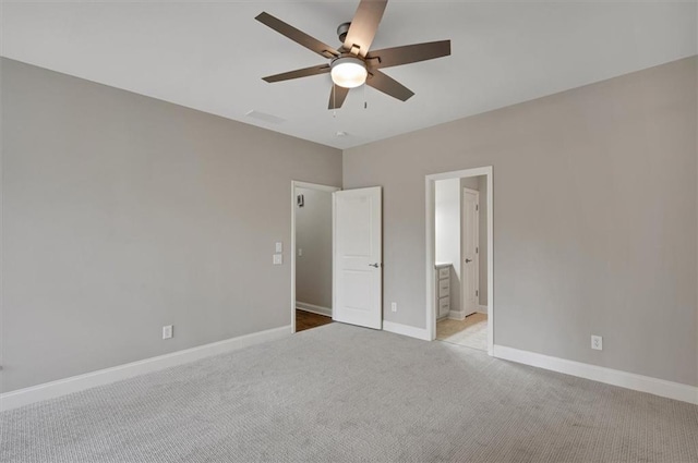 unfurnished bedroom featuring visible vents, baseboards, connected bathroom, ceiling fan, and carpet