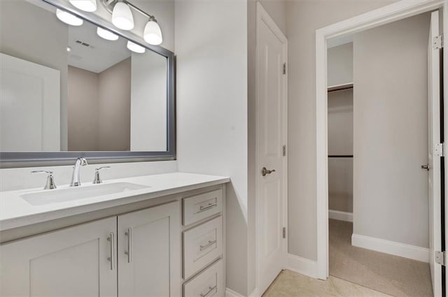 bathroom featuring a closet, visible vents, vanity, baseboards, and tile patterned floors