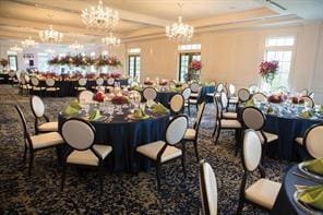 dining area with an inviting chandelier, plenty of natural light, and a raised ceiling