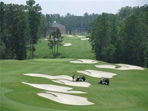 view of home's community featuring a lawn and golf course view