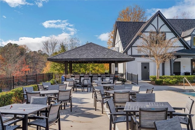 view of patio featuring a gazebo, fence, and outdoor dining space