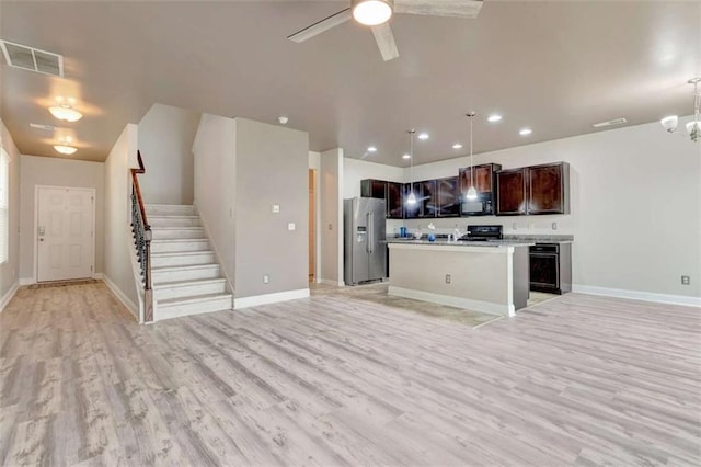 529 Dasheill Ln, Atlanta, GA 30349 - kitchen featuring stainless steel fridge, black microwave, open floor plan, light wood-style floors, and recessed lighting