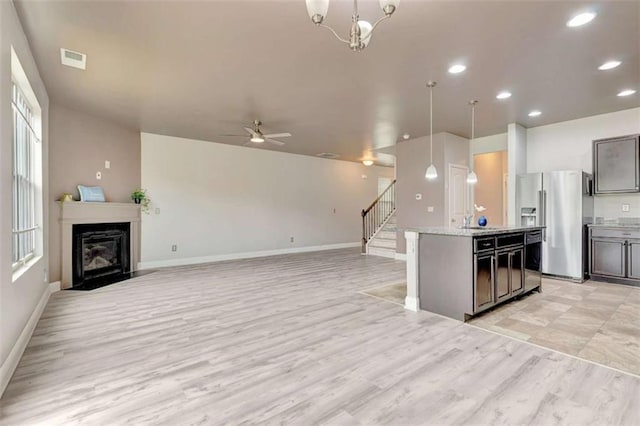 529 Dasheill Ln, Atlanta, GA 30349 - kitchen with stainless steel fridge, light wood-style floors, hanging light fixtures, open floor plan, and recessed lighting