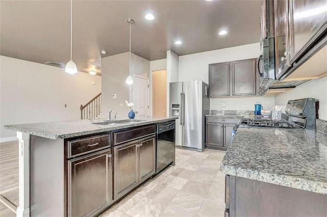 529 Dasheill Ln, Atlanta, GA 30349 - kitchen featuring stainless steel appliances, dark brown cabinets, an island with sink, pendant lighting, and light stone countertops