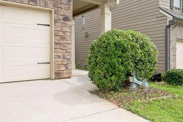 529 Dasheill Ln, Atlanta, GA 30349 - doorway to property featuring driveway, stone siding, and an attached garage