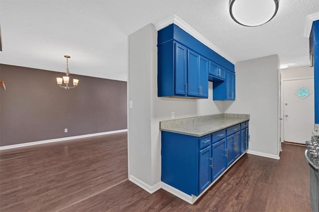 kitchen with a textured ceiling, blue cabinets, pendant lighting, a notable chandelier, and dark hardwood / wood-style floors