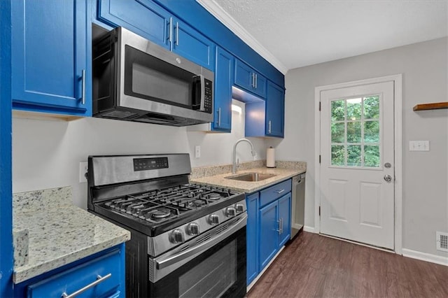 kitchen with stainless steel appliances, sink, blue cabinets, light stone counters, and dark hardwood / wood-style flooring