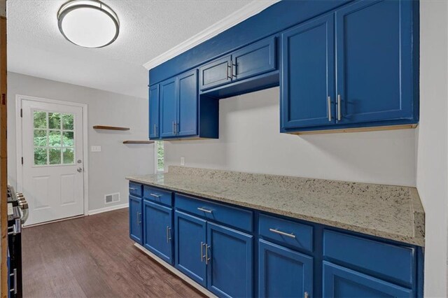 kitchen with blue cabinetry, gas range, light stone counters, and dark hardwood / wood-style flooring