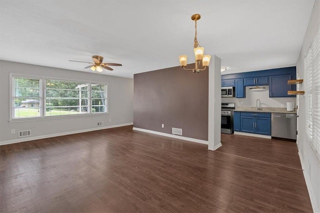 unfurnished living room with dark wood-type flooring, sink, and ceiling fan with notable chandelier