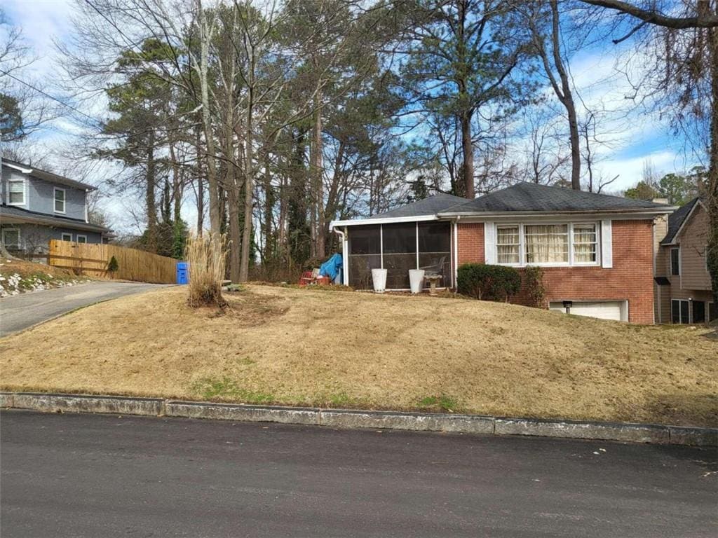 view of front facade featuring a front lawn and a sunroom