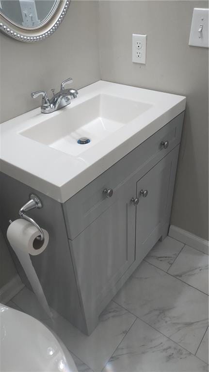 bathroom featuring baseboards, marble finish floor, and vanity