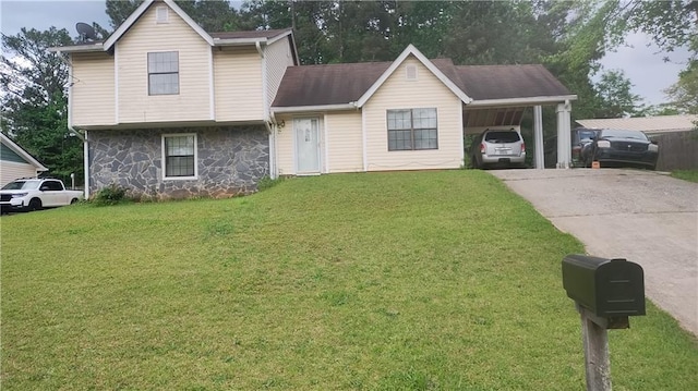 tri-level home featuring a front yard, an attached carport, stone siding, and driveway