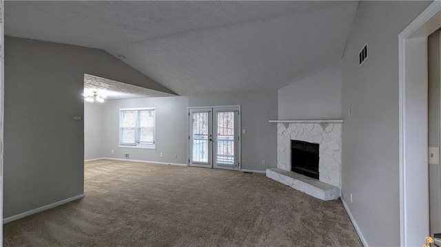 unfurnished living room featuring vaulted ceiling, a stone fireplace, and carpet flooring