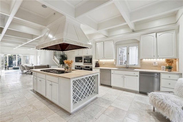 kitchen featuring white cabinetry, sink, coffered ceiling, stainless steel appliances, and custom range hood