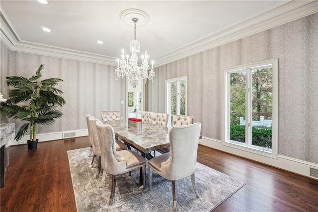 dining area featuring dark hardwood / wood-style flooring, crown molding, and an inviting chandelier