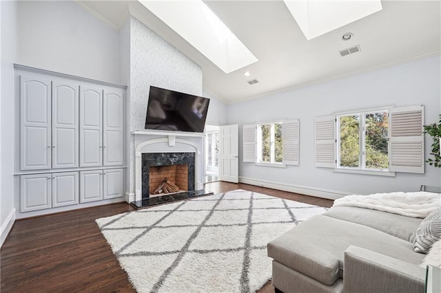 living room featuring crown molding, dark wood-type flooring, a skylight, high vaulted ceiling, and a fireplace