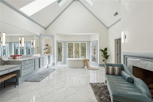 bathroom with a skylight, vanity, a healthy amount of sunlight, and a tub to relax in