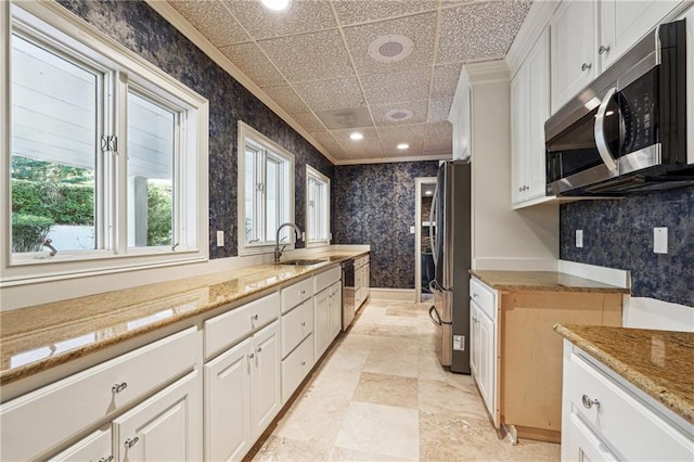 kitchen featuring white cabinetry, sink, crown molding, and appliances with stainless steel finishes