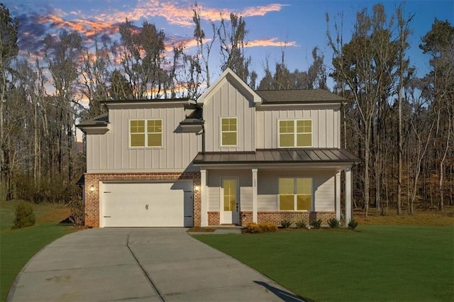 view of front of property featuring a garage and a lawn