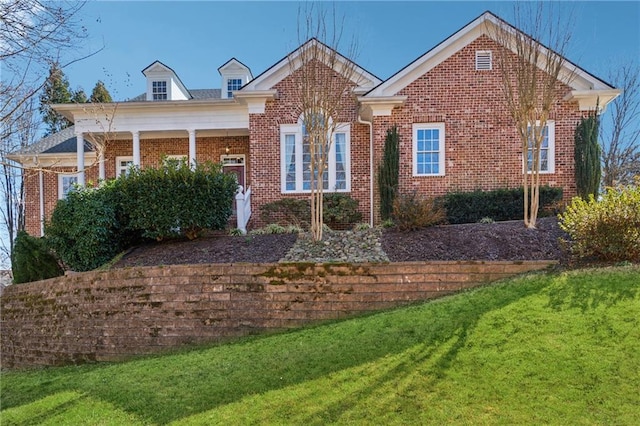 view of front of house with brick siding and a front lawn