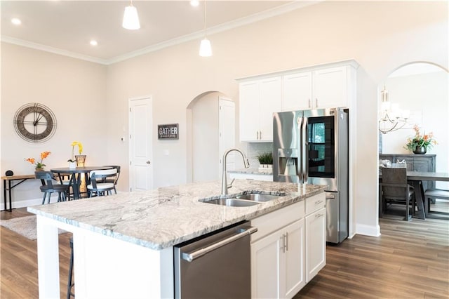 2665 Crowbrook Way, Cumming, GA 30040 - kitchen with stainless steel appliances, a sink, arched walkways, dark wood-style flooring, and white cabinets