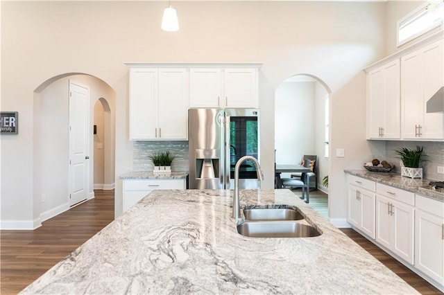 2665 Crowbrook Way, Cumming, GA 30040 - kitchen featuring a sink, stainless steel appliances, arched walkways, dark wood-style flooring, and a towering ceiling