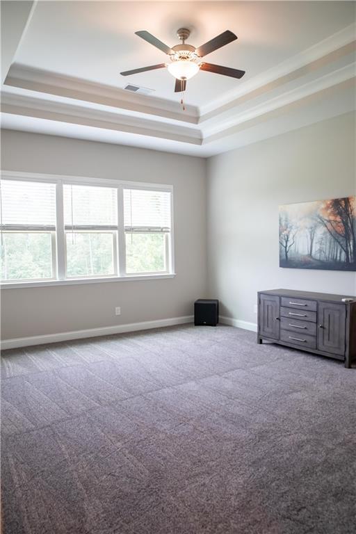 2665 Crowbrook Way, Cumming, GA 30040 - unfurnished living room featuring a tray ceiling, carpet flooring, a ceiling fan, baseboards, and ornamental molding