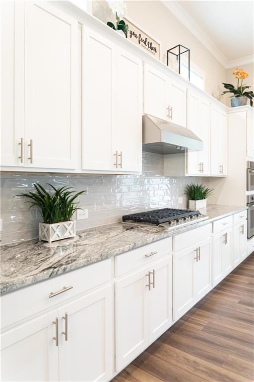 2665 Crowbrook Way, Cumming, GA 30040 - kitchen featuring stainless steel gas cooktop, under cabinet range hood, ornamental molding, and white cabinetry