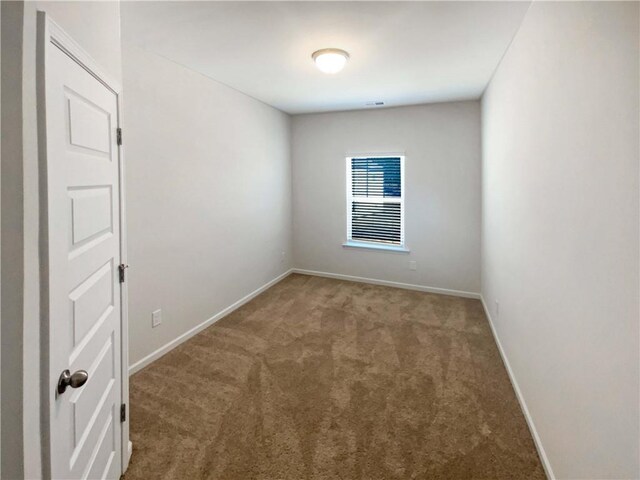 spare room featuring baseboards and carpet flooring