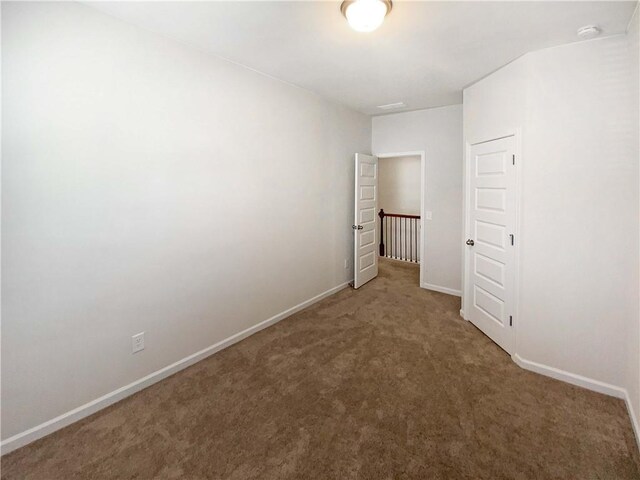 empty room featuring baseboards and carpet floors