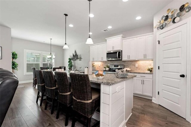 1311 Calgary Lk, Winder, GA 30680 - kitchen featuring appliances with stainless steel finishes, backsplash, white cabinets, dark wood-type flooring, and recessed lighting