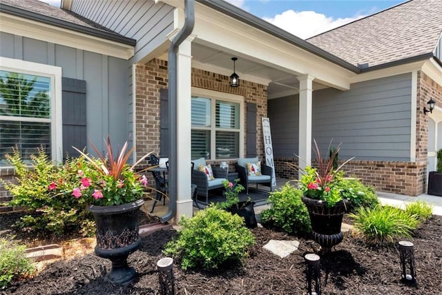 1311 Calgary Lk, Winder, GA 30680 - view of exterior entry with brick siding, a porch, roof with shingles, and board and batten siding