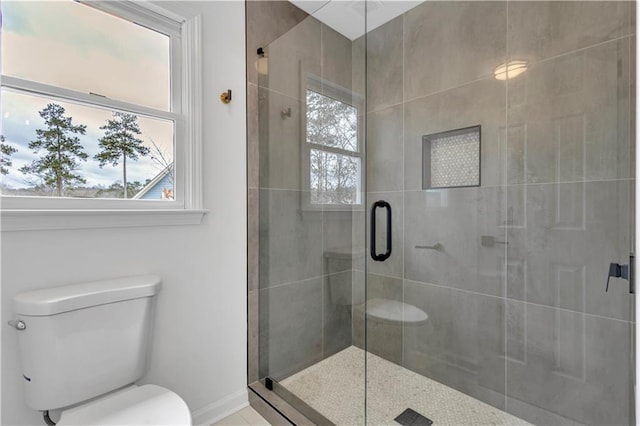 bathroom with a shower with door and toilet