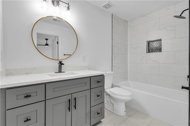 full bathroom with tiled shower / bath, vanity, and toilet