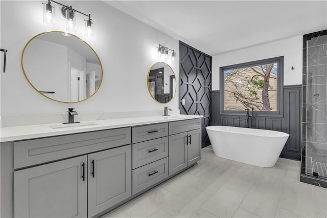 bathroom with tile patterned floors, vanity, a bath, and tile walls