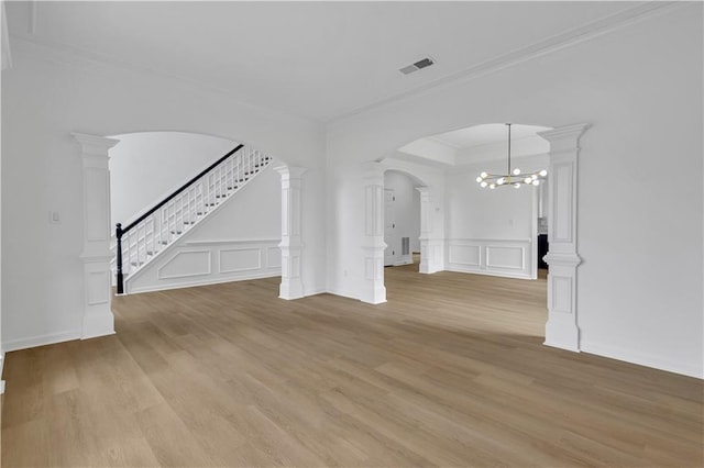 unfurnished living room with ornamental molding, light hardwood / wood-style floors, and ornate columns