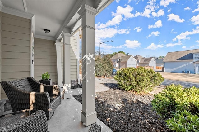 view of yard featuring covered porch and a residential view