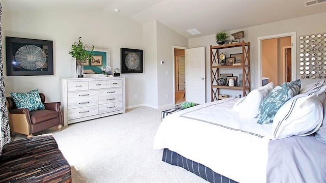 bedroom with connected bathroom, light colored carpet, and lofted ceiling