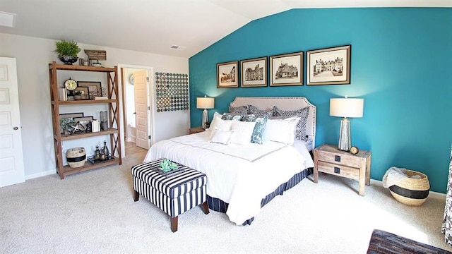 bedroom featuring carpet flooring, ensuite bath, and lofted ceiling