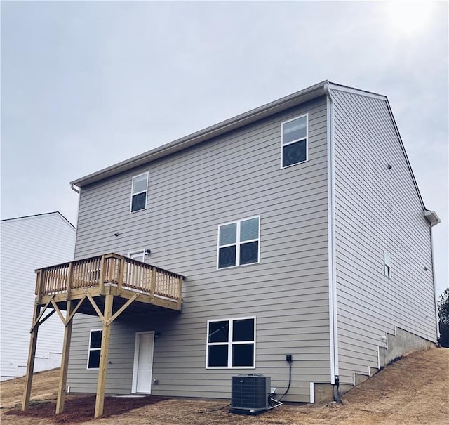 back of property featuring a deck and central AC