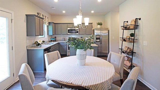 dining area featuring sink, dark hardwood / wood-style floors, and an inviting chandelier